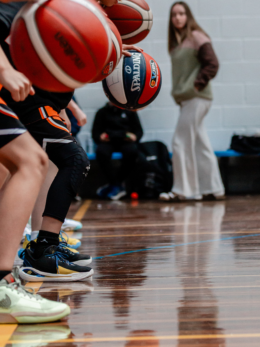 A rack of basketballs courtside